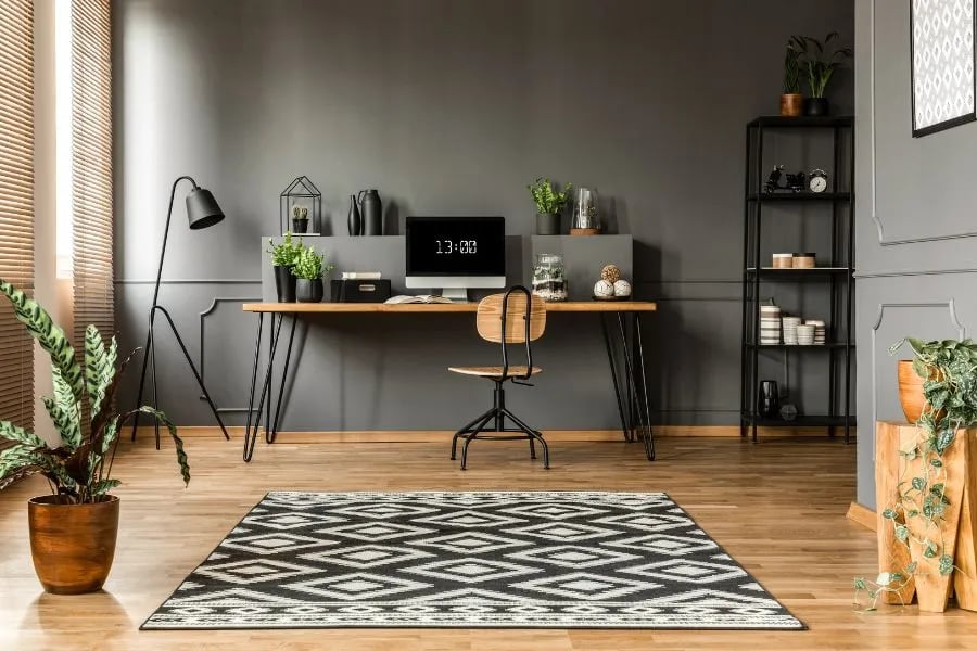 formal living room transformed into home office space with desk rug and shelving