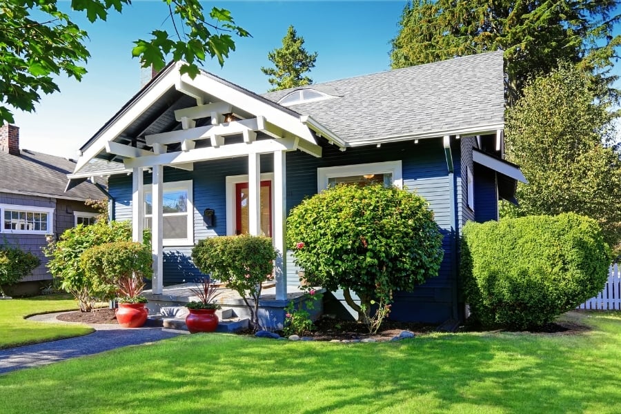 clean and freshly painted blue cottage with green lawn