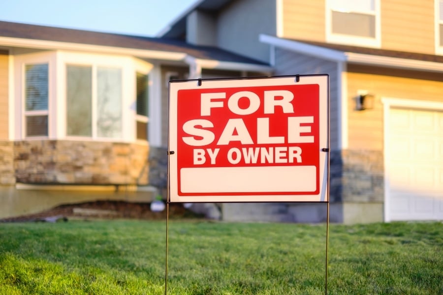 For Sale By Owner sign in yard for home sale