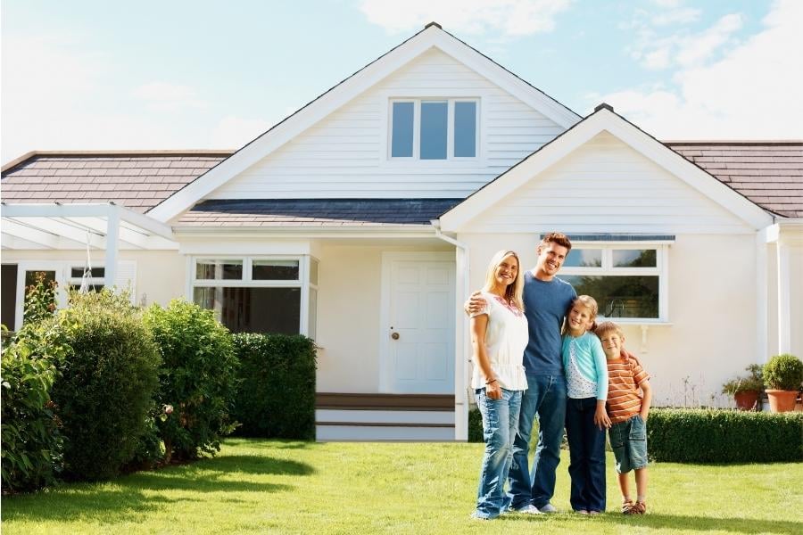 family standing in front of new home