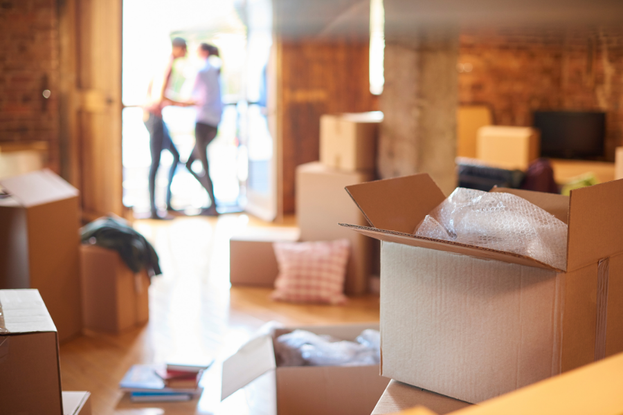 Moving boxes and couple moving into a house