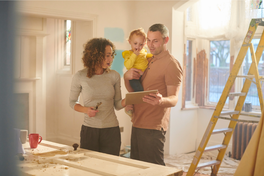 couple and child looking at plans while renovating home
