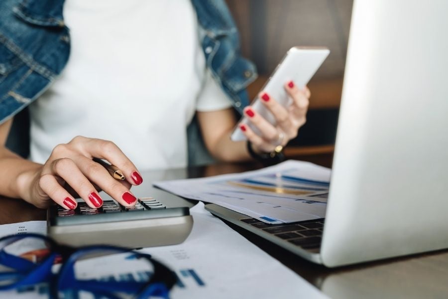 Woman with laptop, phone, and calculator