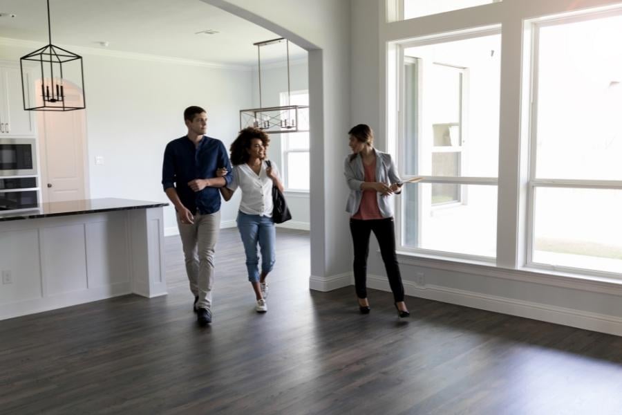 Couple walking through home with realtor