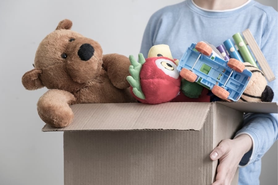 child holding box of toys