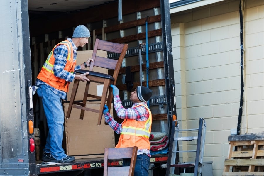 men loading chairs onto moving van