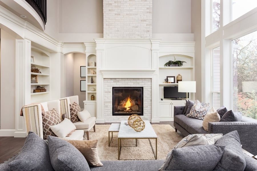 Beautiful white living room with fireplace and fire. 