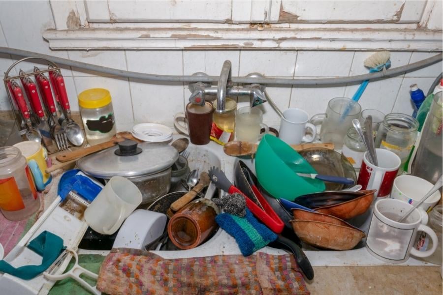 messy sink full of dishes