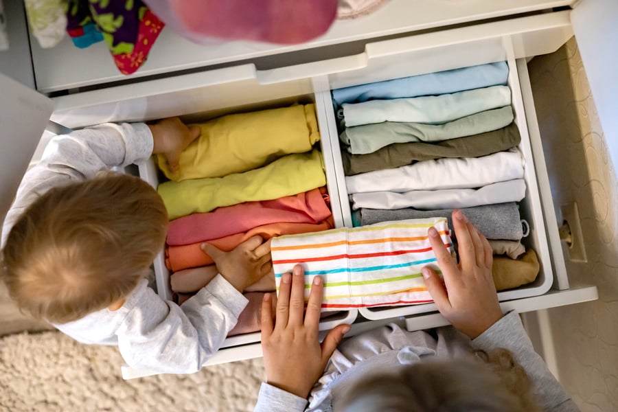 children putting clothes away in closet