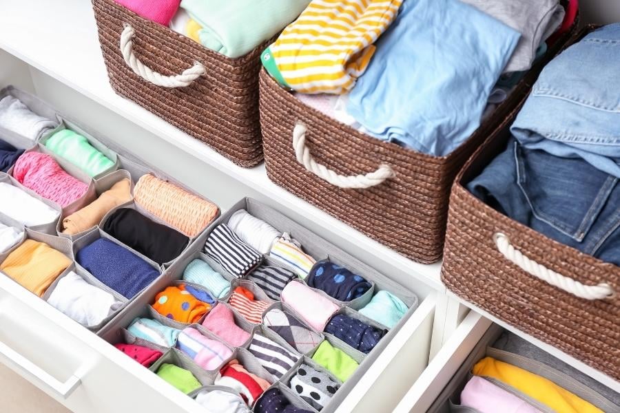 organized drawers and baskets of clothing in kids' closet