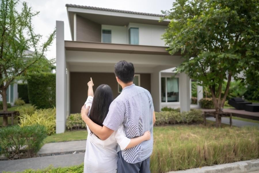 homeowners looking at home exterior and pointing