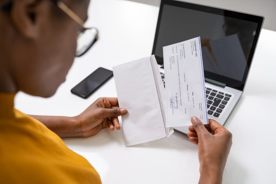 Woman looking at check with laptop