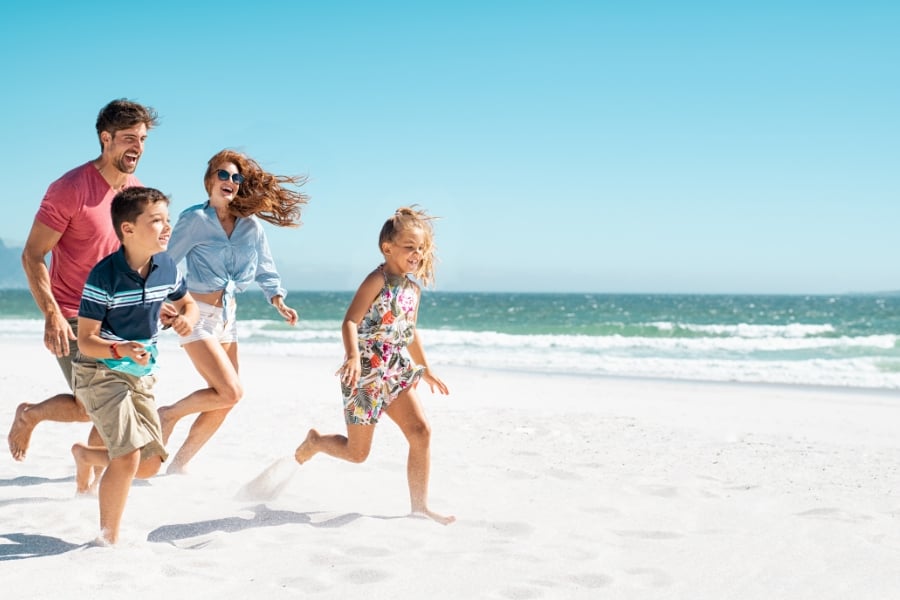 parents and children running on beach