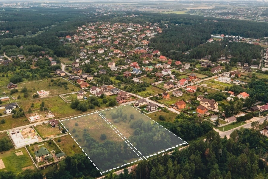 Aerial view of plot of land for sale with houses around.