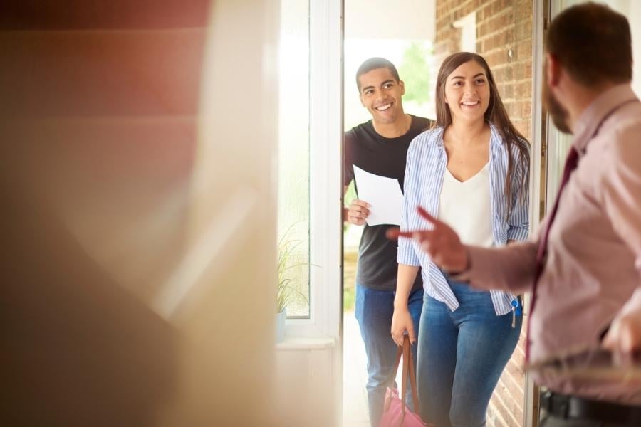 couple opening door to home