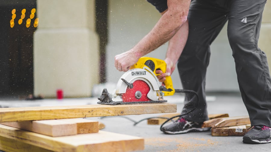 man cutting board with saw