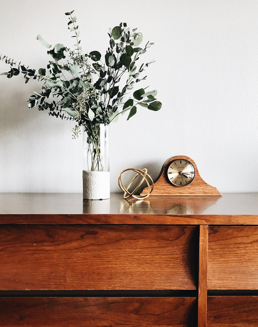 Wooden sideboard with flowers and clock