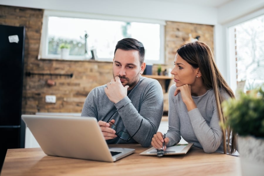 Serious couple talking and looking at computer. 