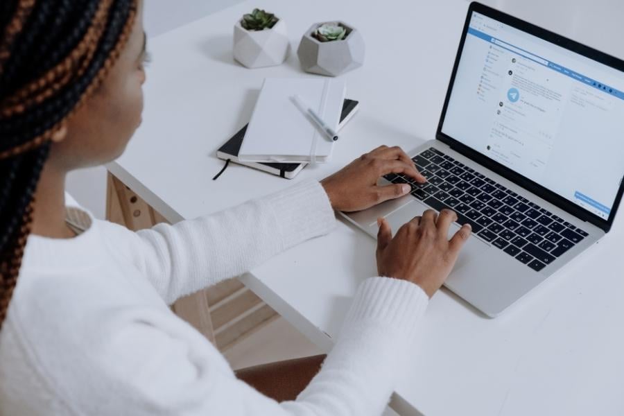 women typing on laptop at desk