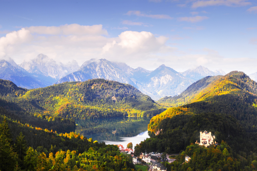 View of the Bavarian Alps in Germany with mountains in autumn surrounding a lake. 