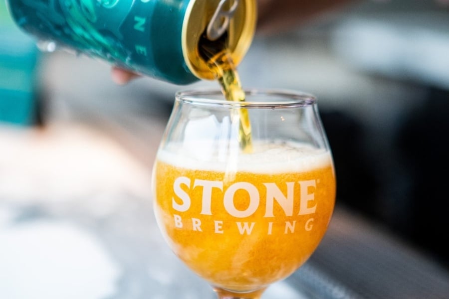 Craft beer being poured into glass with words Stone Brewing