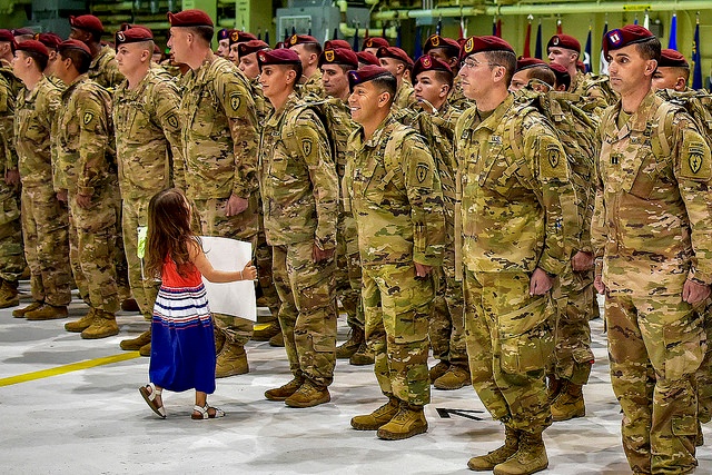 lines of paratroopers and small girl with homecoming sign