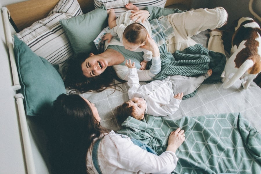 friends laughing together with small children and dog