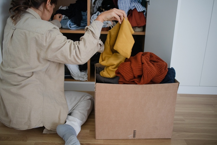woman sorting clothes into box