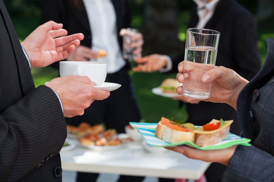 holiday party guests holding drink and food