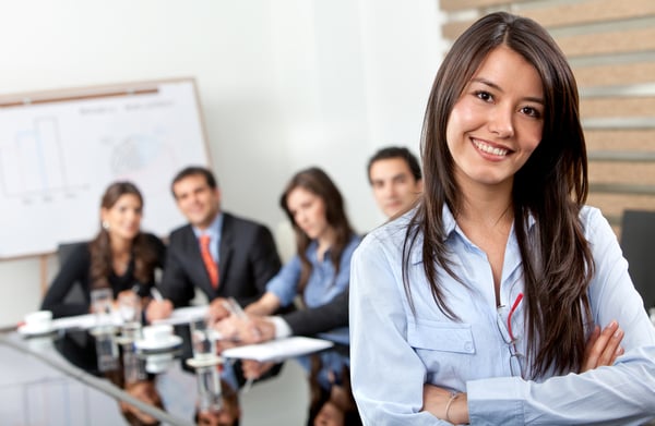 Business woman smiling with her team behind her