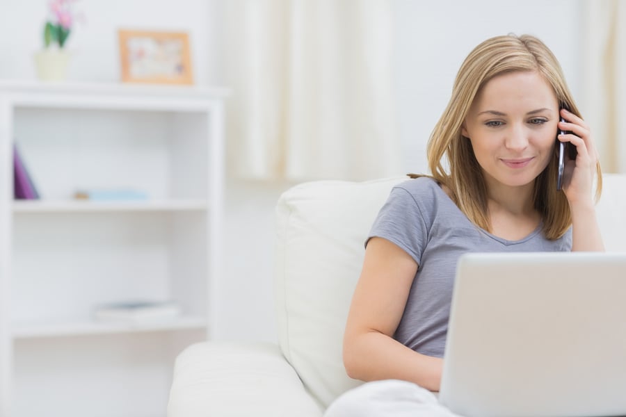 Woman on phone and laptop applying for loan pre-qualification 