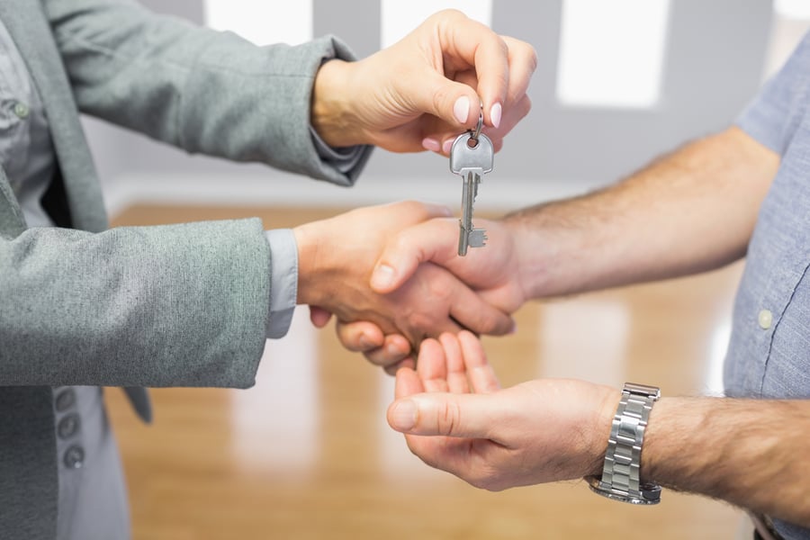 man handing keys to home to another