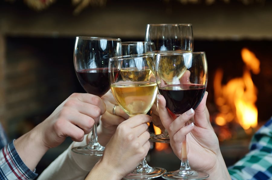 people holding glasses of wine at holiday season