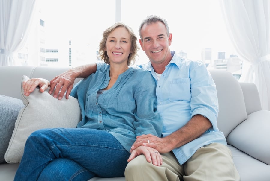 middle aged couple sitting on couch