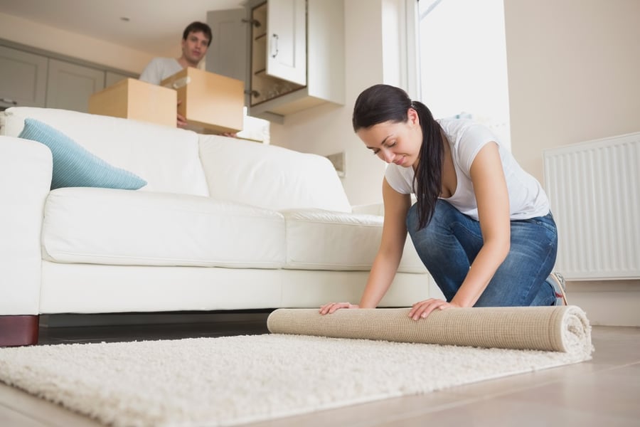 Woman rolling up rug before a move 