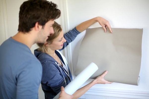 Young couple choosing color of all paper in new home