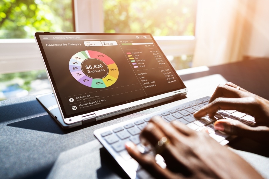 woman's hands typing on laptop showing graph