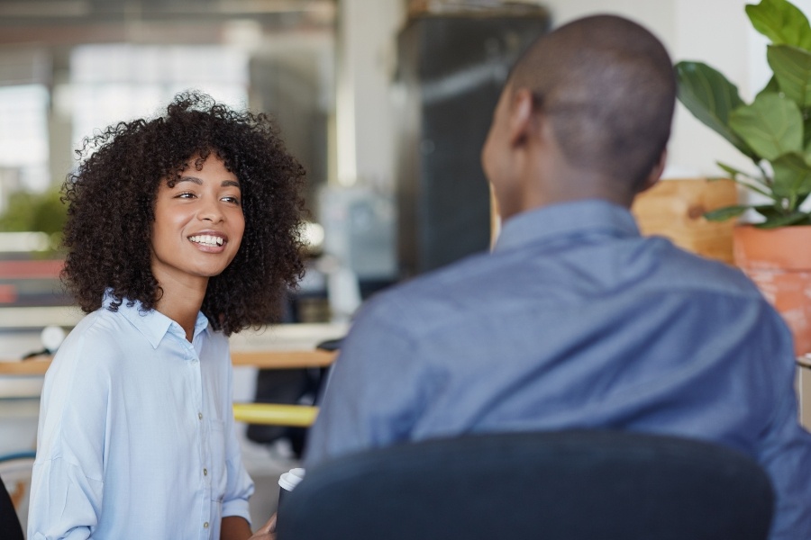 two smiling people talking