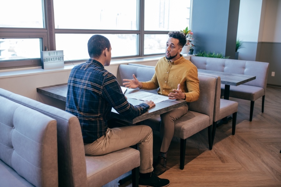 two men talking in restaurant