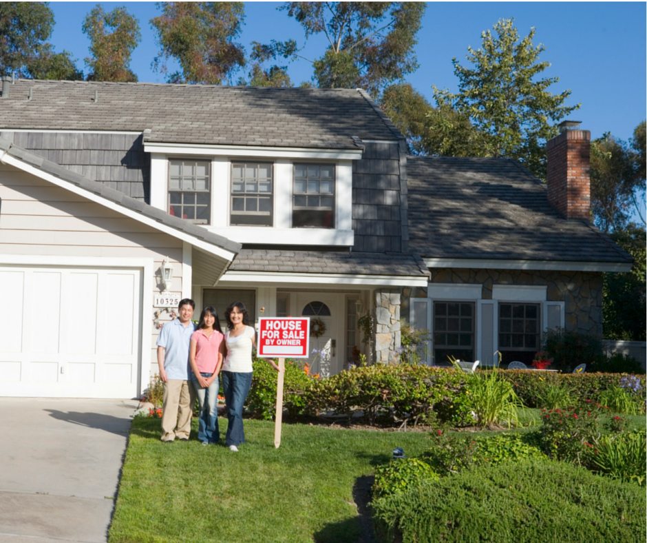 Family in front of home with For Sale sign