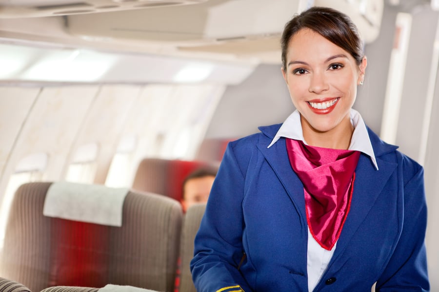 flight attendant in an airplane cabin smiling