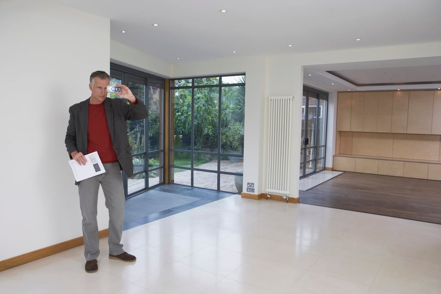 real estate agent taking photo of home for long distance clients