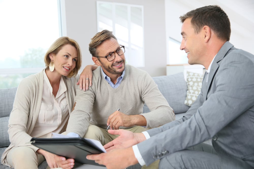 couple discussing home renovation loan with real estate agent