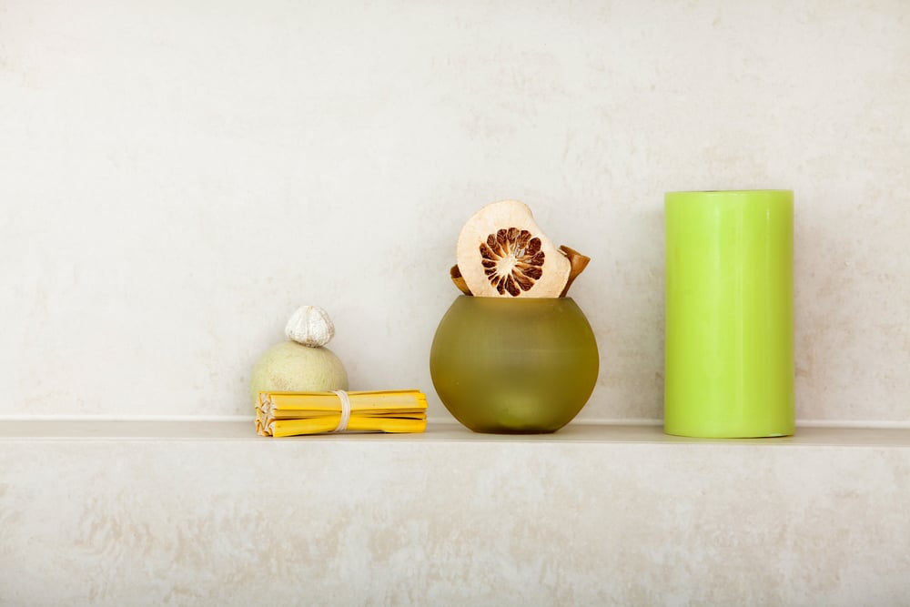 Green spa decorations and candle sitting on bathroom shelf