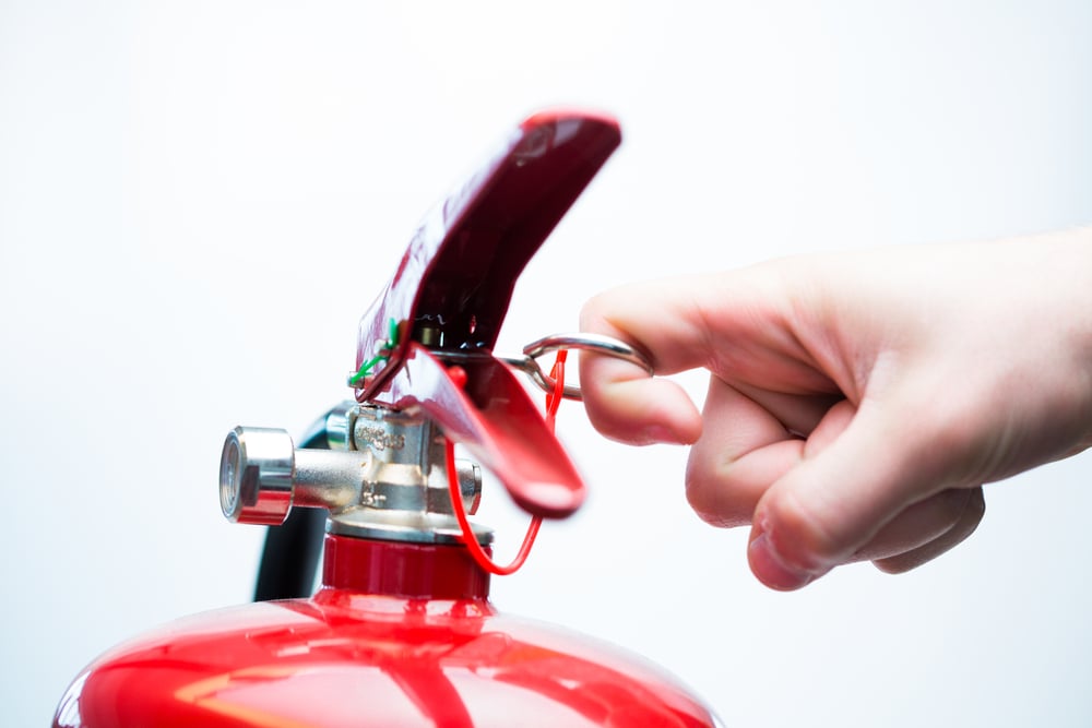 Hand pulling pin of fire extinguisher-1