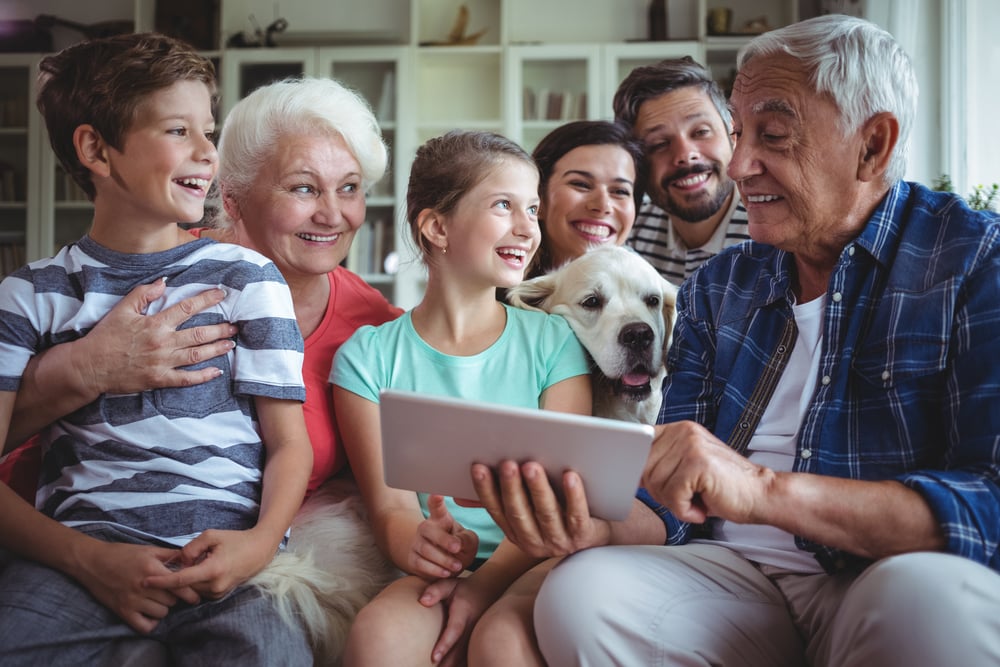 extended family looking at tablet with grandkids