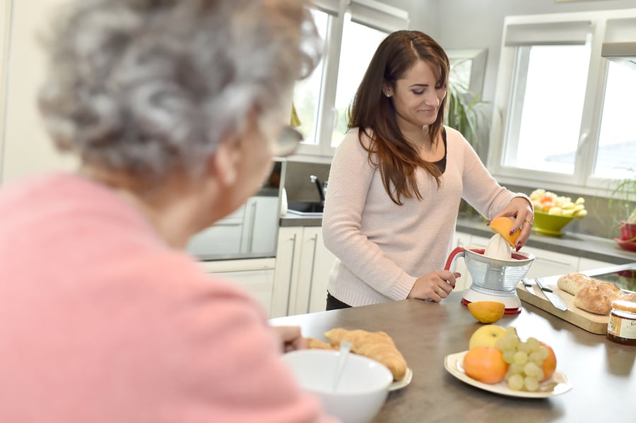 woman making lunch for elderly person as volunteer