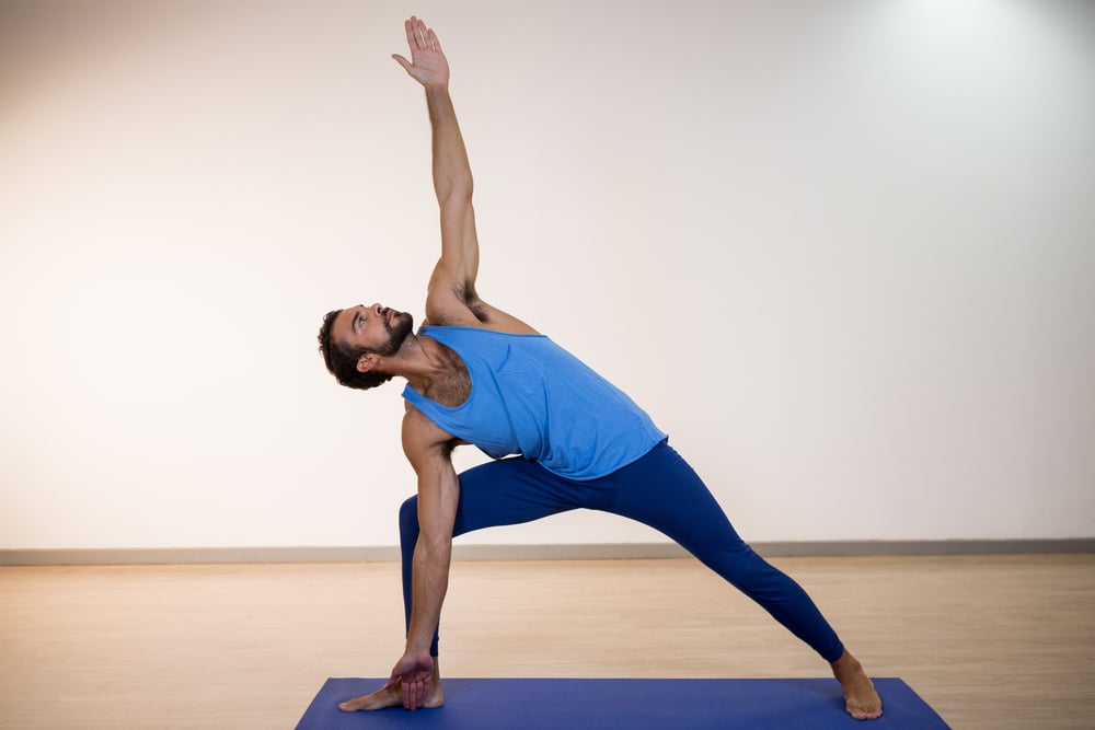 Man performing yoga in gym