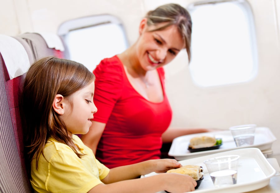 Mother and son having a meal in the airplane while flying