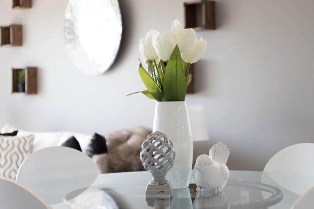 vase of flowers on glass table in open living room